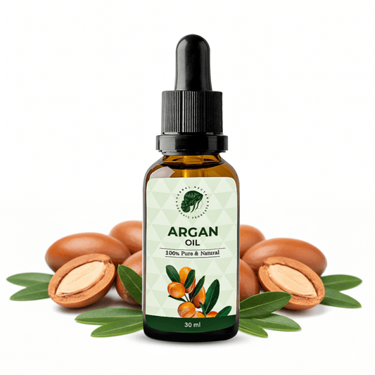 Argan oil dropper bottle with argan nuts and green leaves on white background